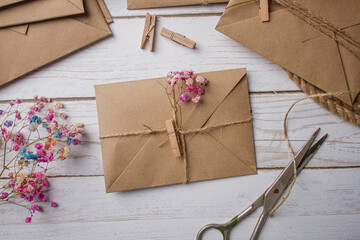 Kraft paper envelope with dried flowers on a light table. Letter in an envelope
