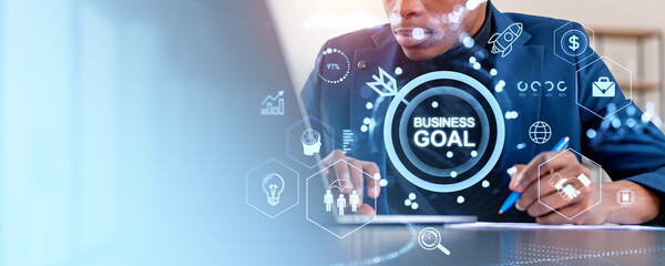 Businessperson setting business goals with digital icons overlay