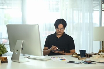 Professional interior designer planning for house project working with material and color samples at office