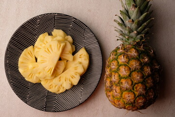 pineapple slices on a black ceramic plate. Ananas comosus. tropical fruit.
