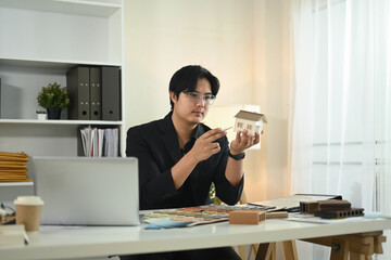 An architect is focused on refining a detailed model at a modern workspace
