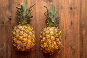 two pineapples on wooden table. Ananas comosus. tropical fruit.