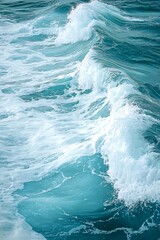 Abstract aerial view of foamy turquoise ocean wave.