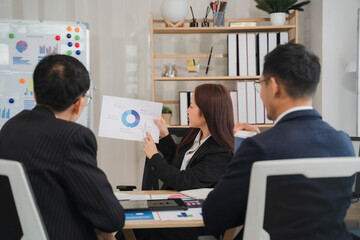 Business Presentation: A professional female leader confidently presents data to her colleagues, showcasing a pie chart during a meeting.  The image captures the essence of strategic planning.
