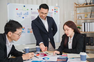 Business Leaders Discussing Strategies: A team of professionals, including an Asian male leader,...