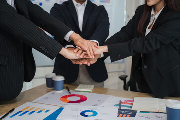 Teamwork Makes the Dream Work: Business professionals unite, hands stacked in a powerful symbol of collaboration and shared success.  A captivating image of unity and synergy in the modern workplace.