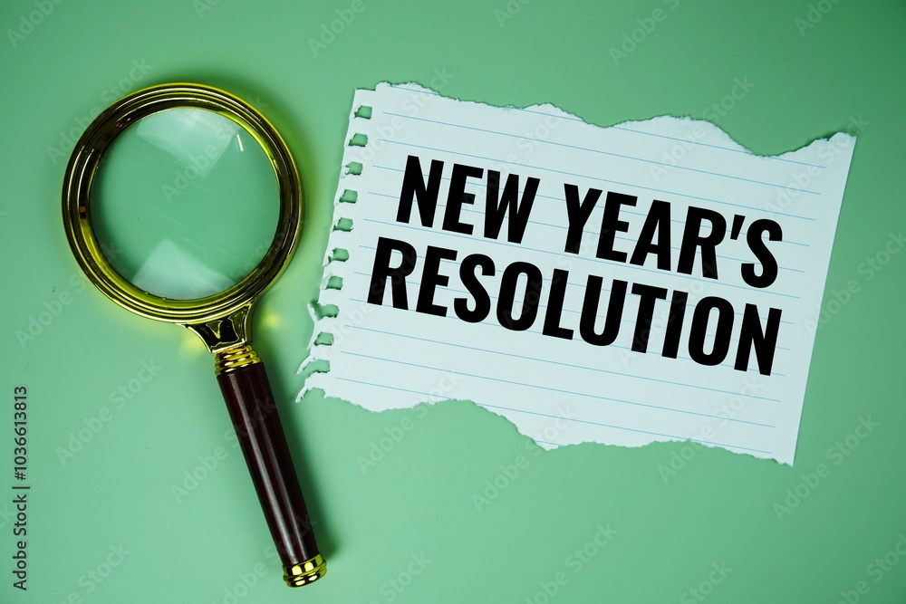 Poster new year's resolution text written on paper torn top view on green background