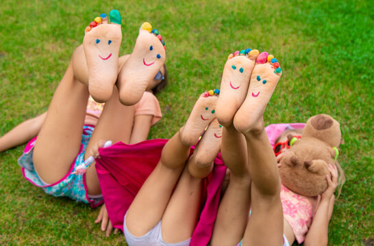 Children's feet painted on the grass. Selective focus.