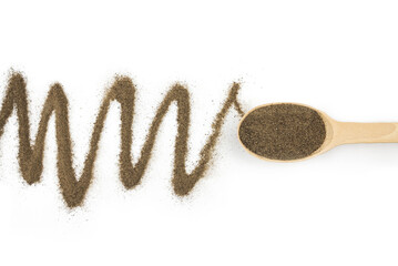 black ground pepper in a wooden spoon on a white background