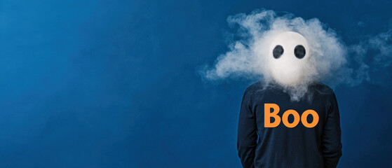 A playful figure stands against a blue background, wearing a shirt that says "Boo," with a foggy, ghostly head effect.
