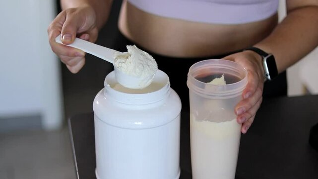Close up of woman preparing a protein shake in the kitchen. Diet meal replacement for weight loss 