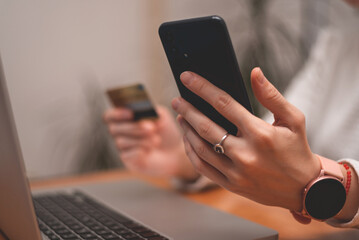Female hands using mobile phone and holding credit card, Online Payment Internet Banking Concept. Woman using smartphone for online banking at home