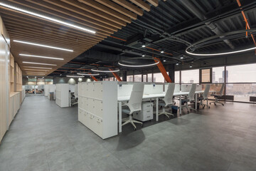 A spacious and contemporary office environment features organized workstations with ergonomic...