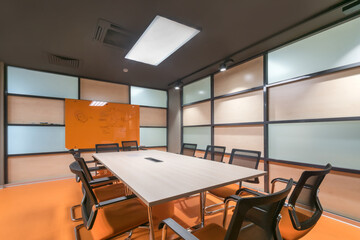 Modern office meeting room, decorated in pastel colors. A long table with comfortable .chairs.