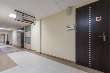 The working floor of a modern office building with a long corridor and doors.
