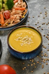Creamy yellow soup with almonds and pasta.