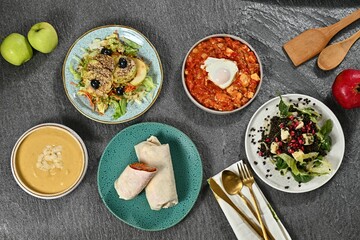 Healthy dishes and fresh apples on textured surface.