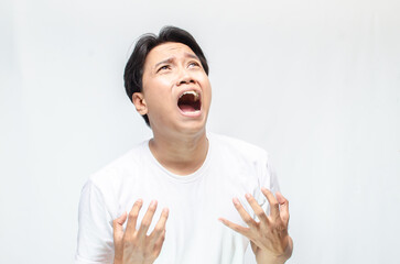 Angry face of young Asian man threatening to cut throat and looking for fight.