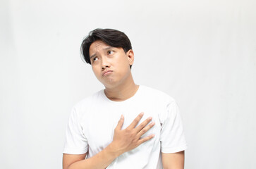 Thoughtful asian man thinking and wondering with hand touching skin as thinking gesture. Thoughtful confused asian man thinking and wondering to choose something. man feeling uncertain and unsure.	