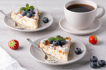 Delicious homemade cake served with fresh fruit and coffee on a rustic wooden table in a cozy morning setting