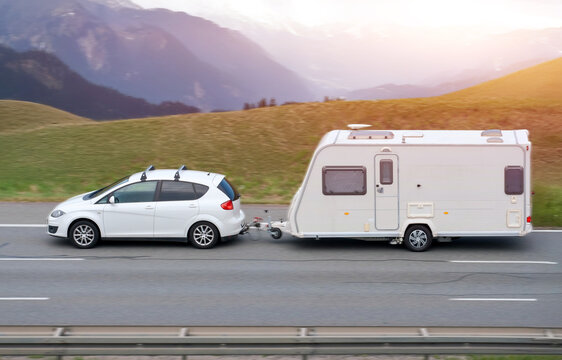 Family Car With RV Van in Mountainous Scenic Landscape During Sunset
