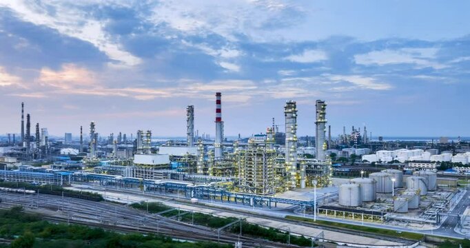 surround aerial time lapse of large refinery at dusk, petrochemical aromatic industry landscape.