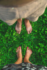 Legs of a woman and a man on the grass. Selective focus.