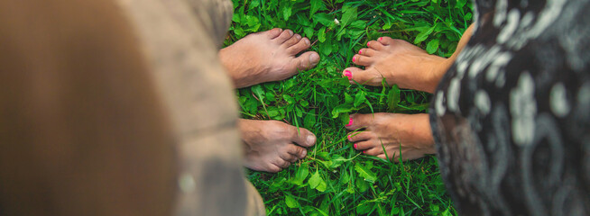 Legs of a woman and a man on the grass. Selective focus.