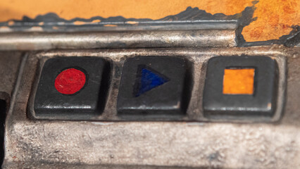 Play, stop and rec buttons on a worn out old radio cassette player.