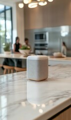 Naklejka premium White speaker on marble countertop in kitchen.