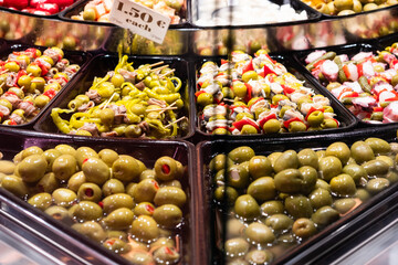 Oliven und Peperoni Spieße an einem Markstand des Mercat de la Boqueria, berühmter Markt an den Ramblas in Barcelona, Spanien