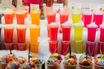 Smoothies und Plastikbehälter mit Früchten auf dem Markt Market La Boqueria in Barcelona, Spanien