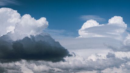 Clouds of different shapes and colors on a blue sky background. A horizontal picture, with a free blue area at the top.