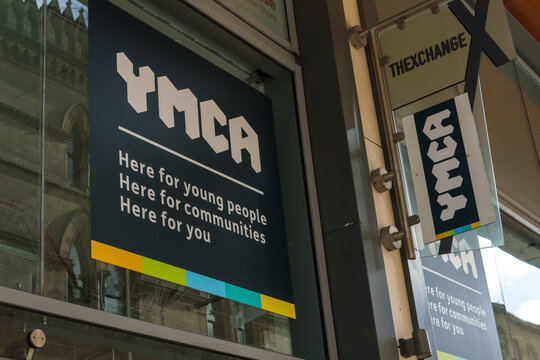 The sign and logo above the YMCA charity shop which raises funds for the humanitarian work of the Christian organisation which seeks to help young people