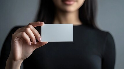 Close-up of a businesswoman holding a blank business card.