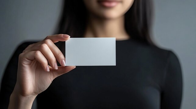 Close-up of a businesswoman holding a blank business card.
