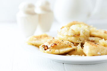 Dumplings with potato and cottage cheese stuffing (pierogi). Traditional Polish Christmas Dinner. Bright background.	