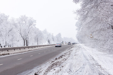 winter interstate road with snow covered trees at overcast day.