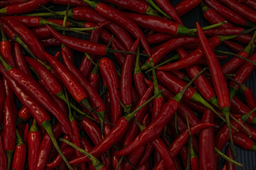 Top view of scattered red hot chili peppers, background.