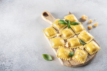 Fresh ravioli pasta on cutting board, top view. Copy space. Italian food.