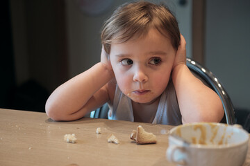 frustrated toddler covering ears during mealtime, expressing overwhelm childhood emotions