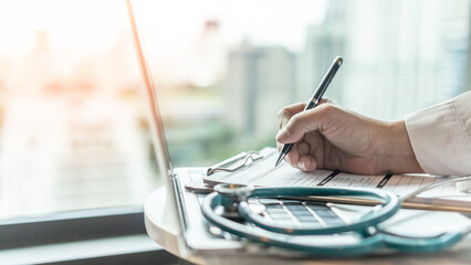 Medical doctor writing on patient personal health care record discharge form, or prescription...