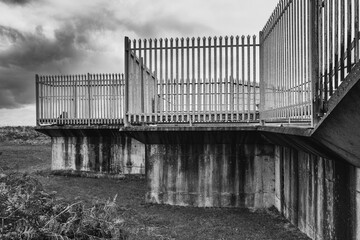 Moody view of 1960s concrete and metal fencing seen at the edge of a now decommissioned English...