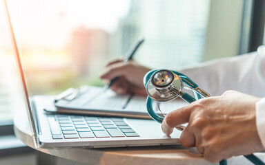 Medical doctor writing on patient personal health care record discharge form, or prescription paperwork in hospital office, clinic center for healthcare and life insurance concept