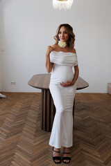 Beautiful slender pregnant girl with makeup and styling in the apartment. A woman waiting for a...