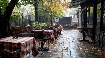 A cozy café terrace with a folded plaid blanket on the table, ready for customers.