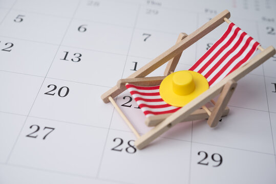 Red beach chair and hat on white blank calendar background copy space. Annual leave travel period for relaxation concept. Period of paid time off (PTO) granted to employees by their employer.