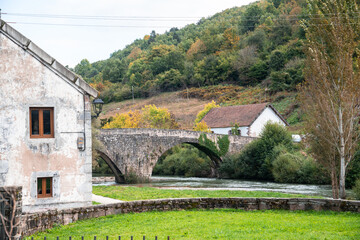 a stone house with a bridge over a river.  Aribe , Navarra