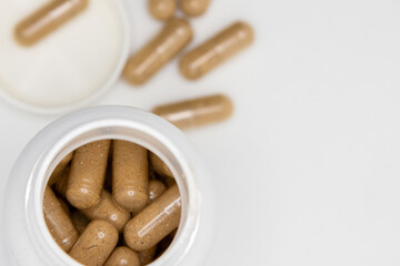 pills spilling from an open bottle on white background