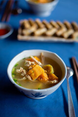 Selective focus on hot soup with chicken and pumpkin served in  bowl. Tasty food in Vietnam..